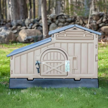 Beige plastic chicken coop on grass with a forest background